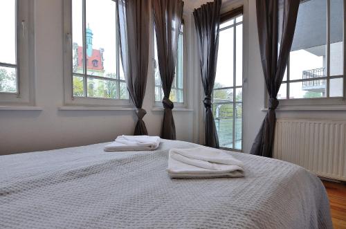 sypialnia z 2 ręcznikami na łóżku z oknami w obiekcie Victus Apartamenty, Apartament Petit w mieście Sopot