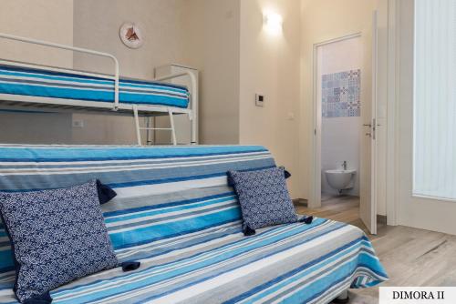 a bedroom with two bunk beds with blue and white pillows at La Dimora sull'Arco in Monopoli
