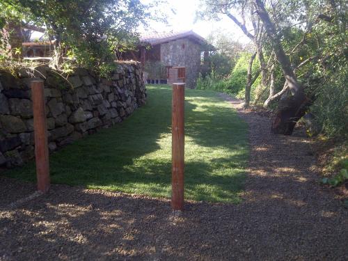 a wooden pole in front of a stone wall at La Quercia in Arbus
