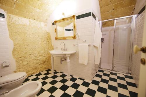 a bathroom with a sink and a toilet and a shower at Le scuderie di Villa Ravenna Luxury House in Sannicola