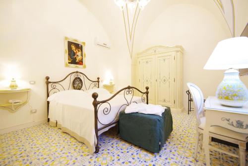 a bedroom with a bed and a table and a stool at Le scuderie di Villa Ravenna Luxury House in Sannicola