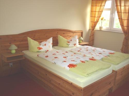 a bedroom with a large bed with flowers on it at Landhotel zum Honigdieb in Ribnitz-Damgarten