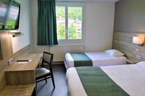 a hotel room with two beds and a desk and a television at Jura Hotel Restaurant Le Panoramic in Saint-Claude