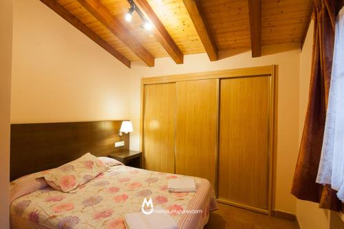 1 dormitorio con 1 cama y armario de madera en Casa Rural Eleizondo Haundia, en Itziar