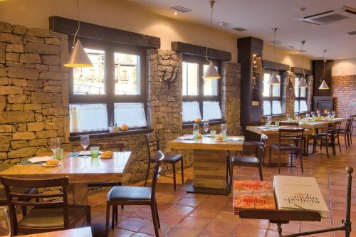 a restaurant with wooden tables and chairs and windows at Hotel Nochendi in Cangas de Onís