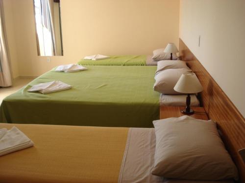 a group of three beds in a room at Villaggio dos Ventos in Arraial do Cabo