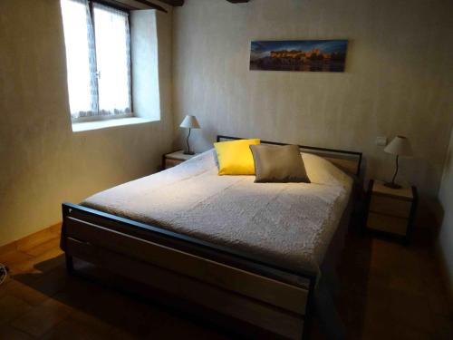 SernhacにあるLa Petite Maison De Velinaのベッドルーム1室(大型ベッド1台、黄色い枕付)