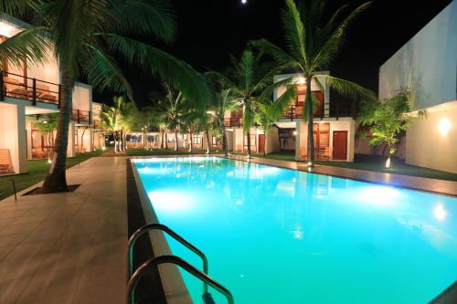 a swimming pool at night with a resort at Arugambay Roccos in Arugam Bay