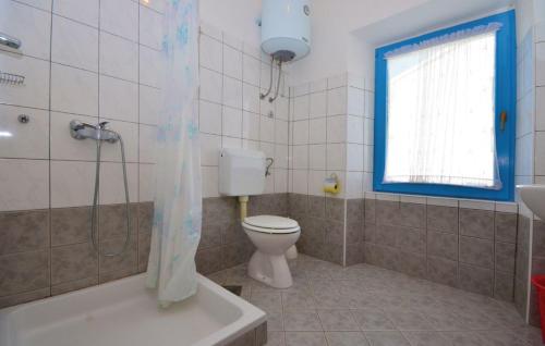 a bathroom with a toilet and a tub and a sink at Holiday House Ivana in Dobropoljana