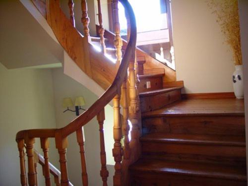 a staircase in a home with a wooden stair case at La Puerta de la Ribera in Sardón de Duero