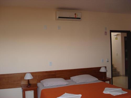 a bedroom with a bed with two white pillows at Villaggio dos Ventos in Arraial do Cabo