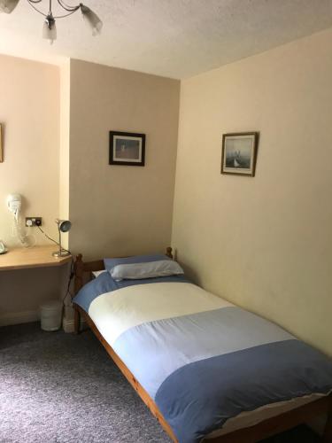 - une chambre avec un lit et un bureau dans l'établissement Cripple Creek Bed And Breakfast, à Rowlands Castle