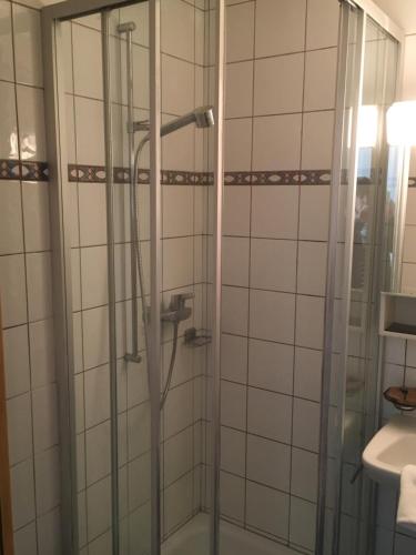 a shower with a glass door in a bathroom at Hôtel de la Gare in Yvonand