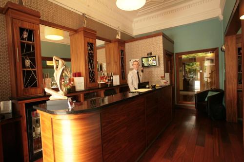 a woman standing at a bar in a restaurant at Acorn Hotel in Glasgow