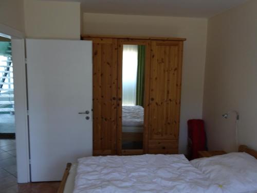 a bedroom with a bed and a wooden door at Strandleben 4 in Grömitz