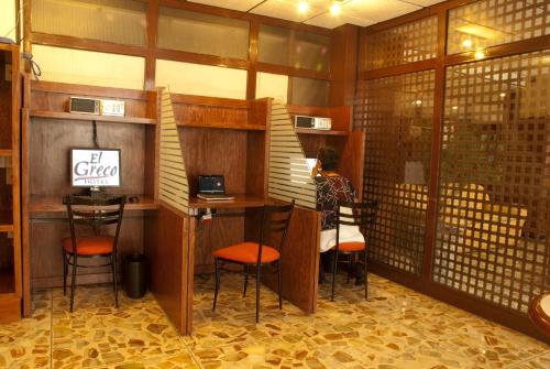 a woman sitting at a desk in a room with a laptop at Hotel El Greco in Mexico City