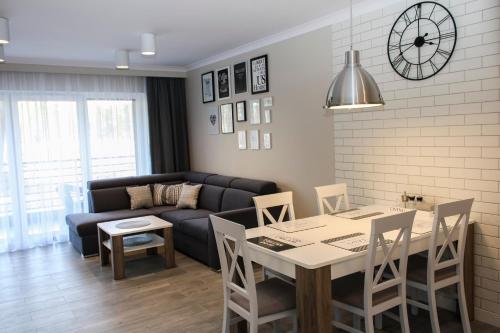 a living room with a table and a couch at Apartament Luxury in Pogorzelica