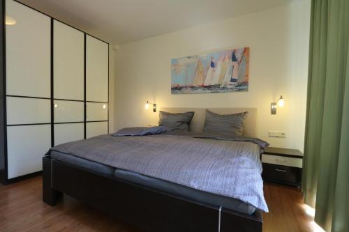 a bedroom with a bed and a painting on the wall at Villa Harmonie W1 in Göhren-Lebbin