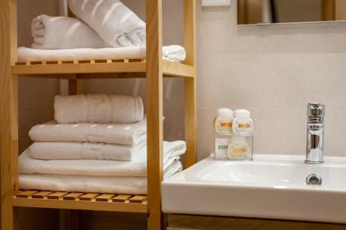 a bathroom with a stack of towels and a sink at Sunny Garden Lux in Split