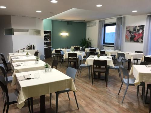 a dining room with white tables and chairs at Hotel Gardenia in Romano Canavese
