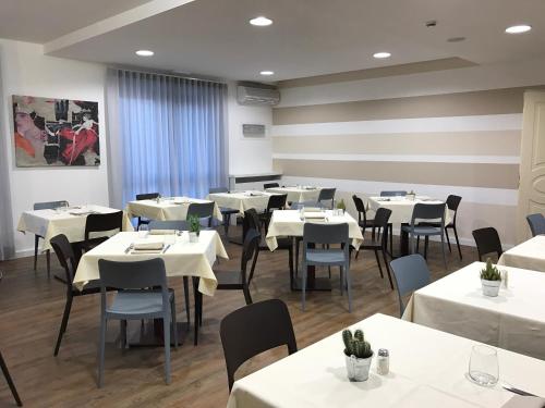 a dining room with white tables and chairs at Hotel Gardenia in Romano Canavese