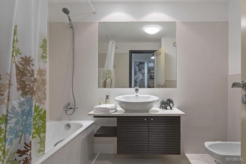 a bathroom with a sink and a tub and a mirror at Rodamar I by An Island Apart in Funchal