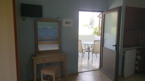 una stanza con specchio e tavolo con sala da pranzo di Koxyli Studios a Vassiliki