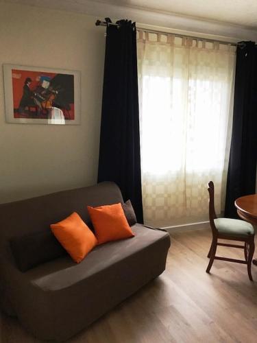 a couch with two orange pillows in a living room at Auberge Casa Mathea in Poggio-di-Venaco