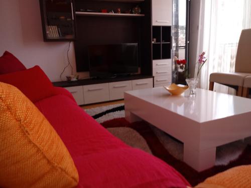 a living room with a red couch and a table at Apartments Stan in Sarajevo