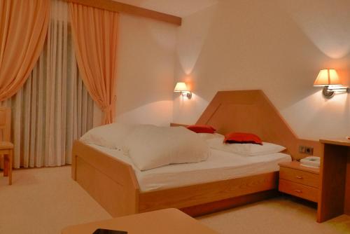 a bed in a hotel room with two pillows on it at B&B Hotel Mair am Turm in Tirolo