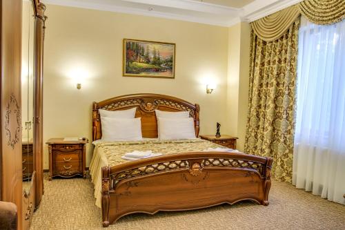 a bedroom with a wooden bed and a window at Dayana Hotel in Simferopol