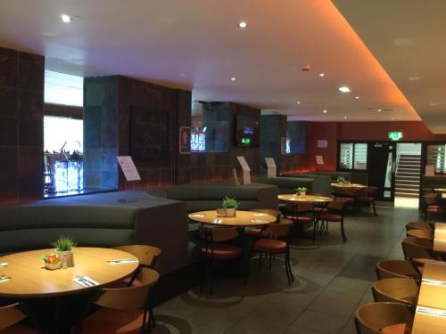 ein Restaurant mit Tischen, Sofas und Stühlen in der Unterkunft West Park Hotel in Clydebank