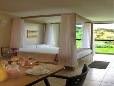 um quarto de hotel com uma cama e uma mesa com uma mesa em Resort Monte das Oliveiras em Joanópolis