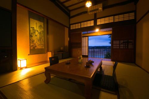 sala de estar con mesa de madera y ventana en Isamikan, en Nakagawa