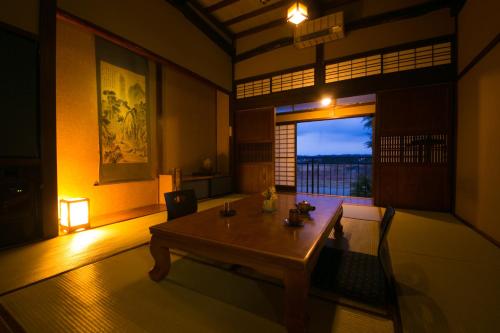 a living room with a wooden table and a window at Isamikan in Nakagawa