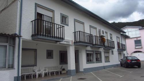 un edificio con tavoli e sedie in un parcheggio di Residencial Martinho a Lousã