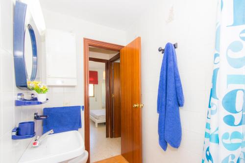 a bathroom with a toilet and a blue towel at Apartamentos Giralda in Chiclana de la Frontera