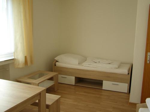 a small room with a bed and a table at Apartment Bexor D19 in Hannover