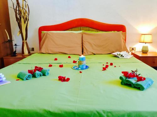 a bed with a table with a candle and flowers on it at Mazzitelli Apartment in Capo Vaticano