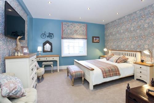 ヨークにある3 The Kings in the heart of Yorkの青い壁のベッドルーム1室、ベッド1台、デスクが備わります。