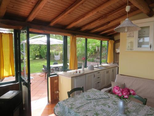 SantʼAlfioにあるLa Perlaのテーブル付きのキッチン、黄色いカーテン付きのキッチン