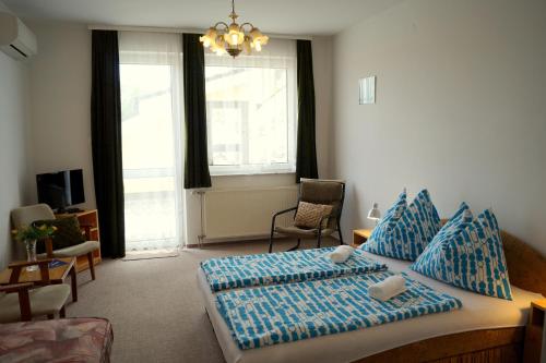 1 dormitorio con 1 cama con almohadas azules en Arizona apartman, en Siófok