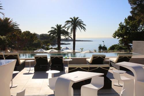 a patio with chairs and tables and a pool at Hotel Son Caliu Spa Oasis in Palmanova