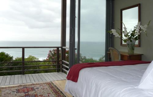 a bedroom with a bed and a view of the ocean at Seaview Apartment in Muizenberg in Muizenberg