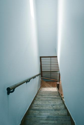 a stairway leading up to a room with a white wall at Nanni Saiin Machiya in Kyoto
