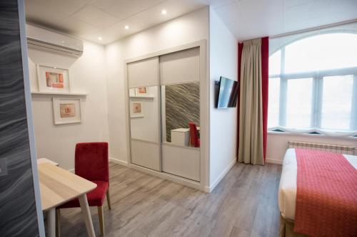 a room with a bed and a desk and a window at Hotel Santa Cruz in Cangas de Onís