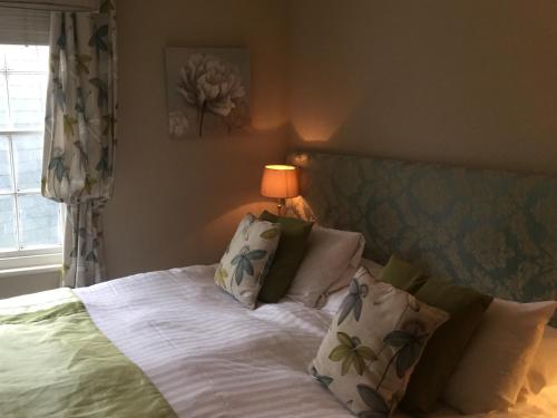 sypialnia z łóżkiem z białą pościelą i poduszkami w obiekcie Ship inn w mieście St Austell