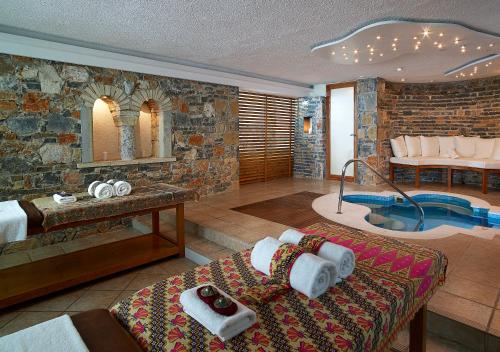 a hotel room with a tub and a bed and a bathroom at Thalassa Villas in Agios Nikolaos
