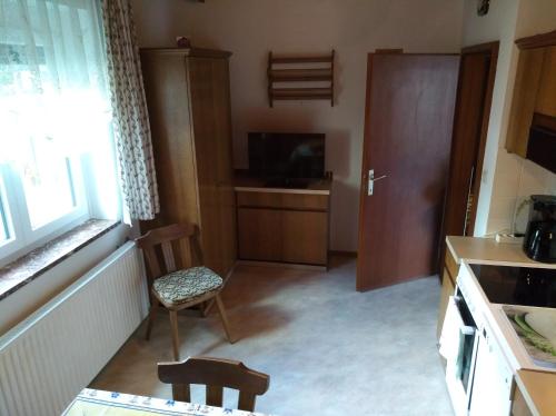 a kitchen with a table and a chair and a television at Haus Friedburg in Velden am Wörthersee