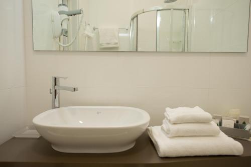 a bathroom with a sink and a mirror and towels at Best Western Hotel Luxor in Turin